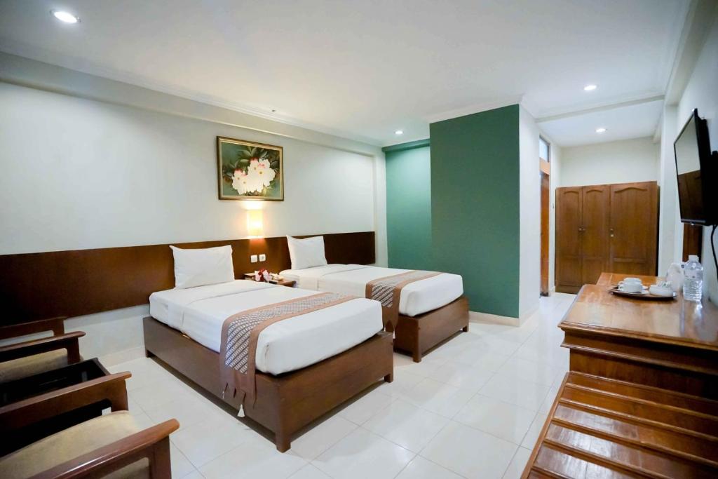 Postel nebo postele na pokoji v ubytování Cakra Kembang Hotel