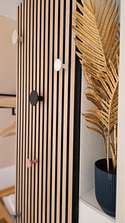 eine Holztür mit einer Topfpflanze auf einem Regal in der Unterkunft ٤Neu٤Fantastischer Meerblick-Stylish-King Bed-PP in Scharbeutz