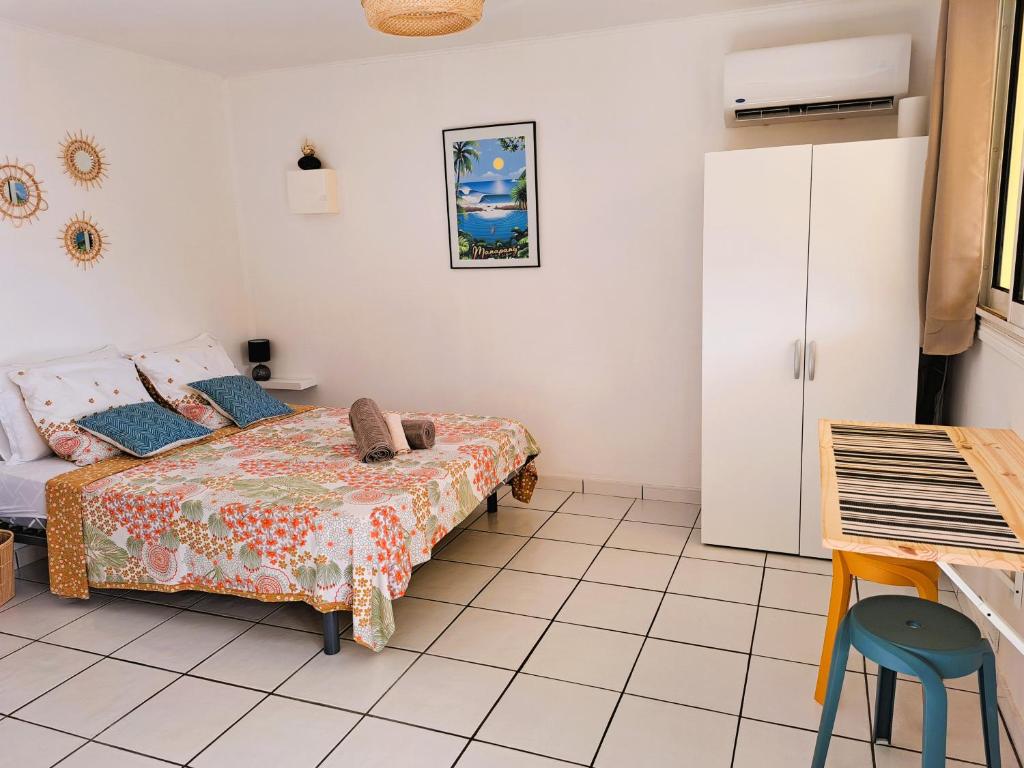 1 dormitorio con 1 cama y nevera en Bungalow Jazz - Bassin Manapany-Les-Bains, en Saint-Joseph