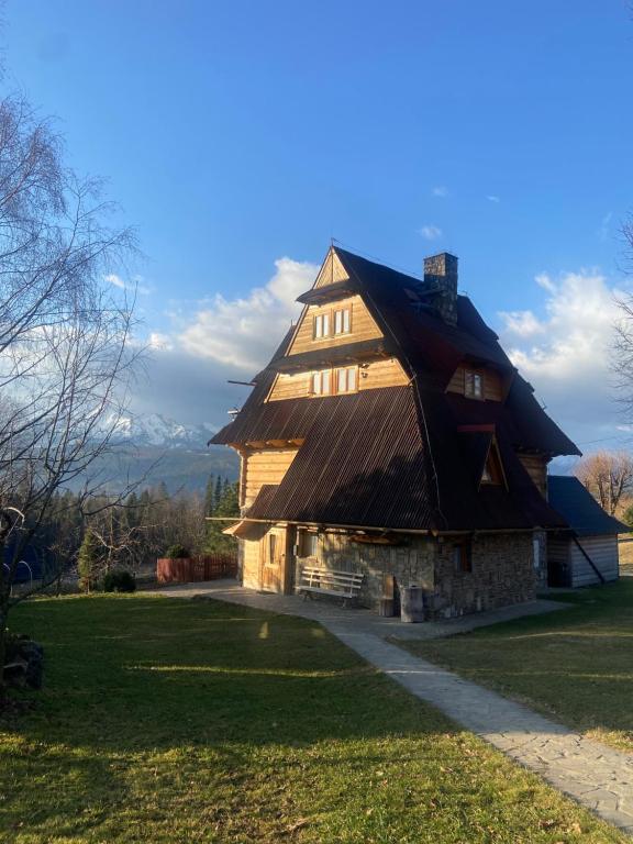 a large wooden house with a gambrel roof at Zakątek w Dolinie in Łapszanka