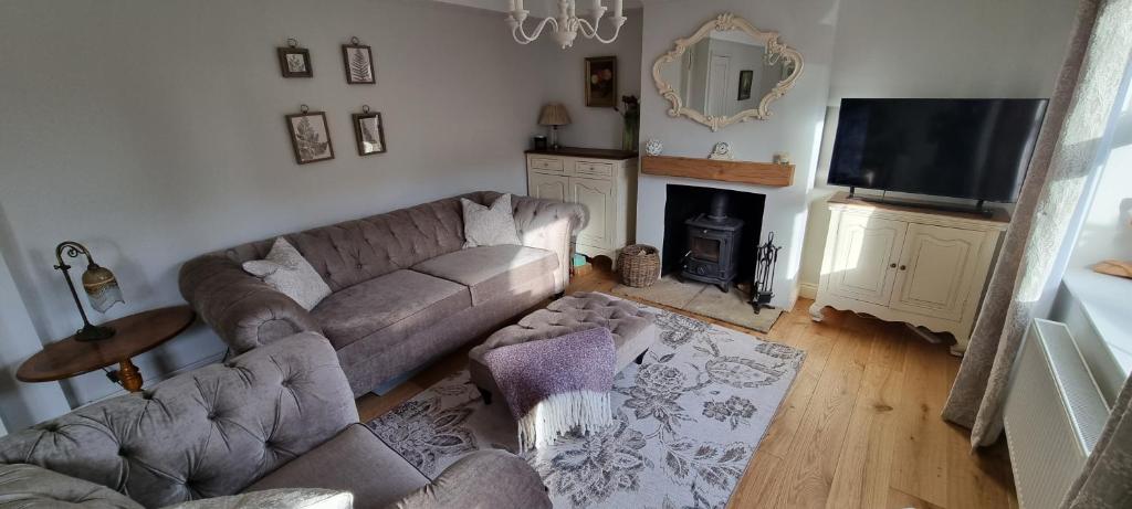 ein Wohnzimmer mit Sofa und Fernseher in der Unterkunft Wren Cottage in Heacham