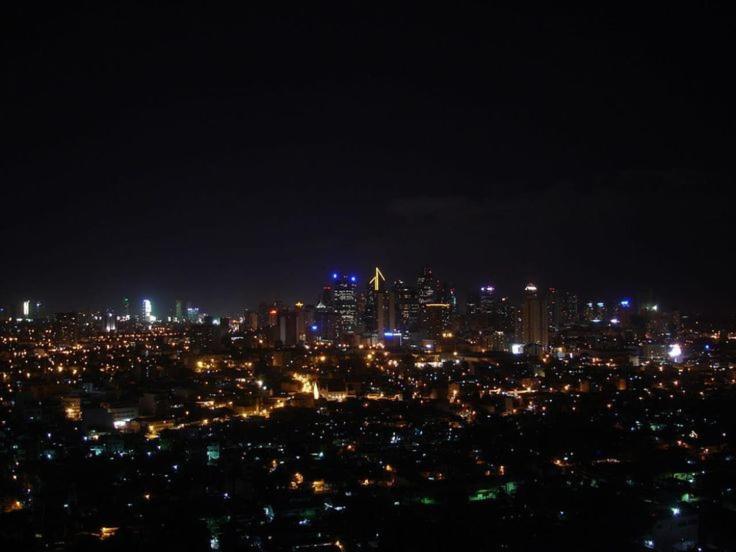 Blick auf die Stadt in der Nacht mit Lichtern in der Unterkunft AZURE HOTEL RESORT Ph15 St Tropez in Manila