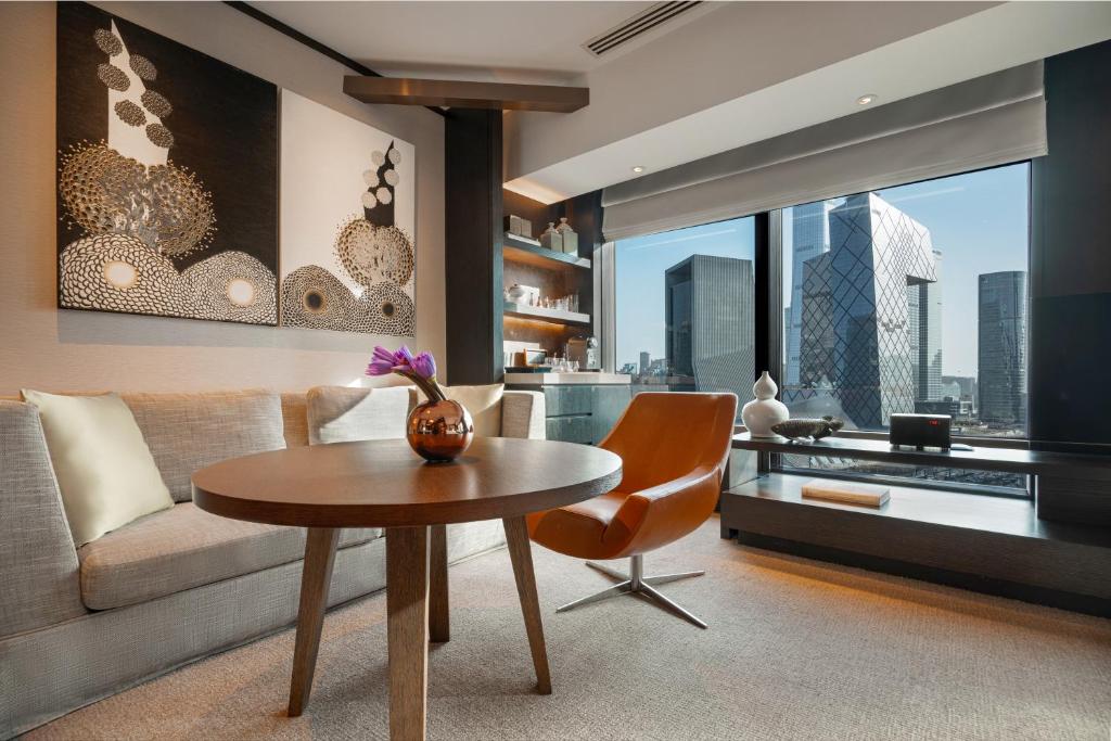 a living room with a table and a couch at Rosewood Beijing in Beijing