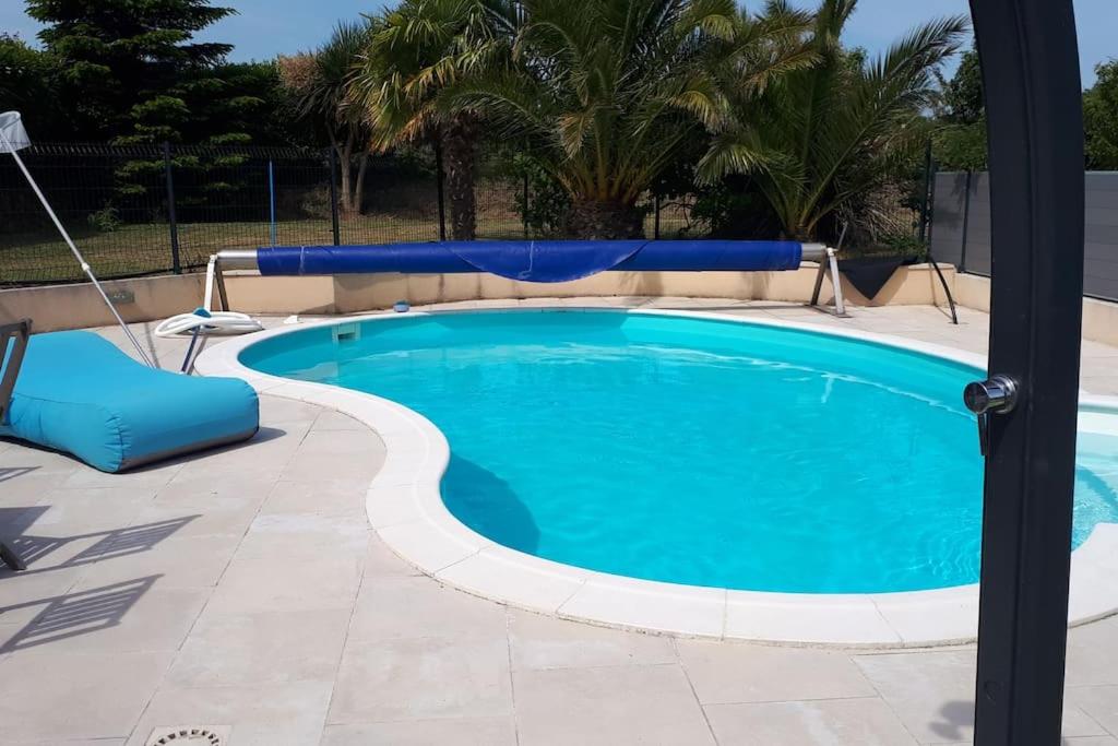 a large swimming pool with a blue pool at Villa Folie Douce, accueille 10 pers avec Piscine in Réthôville