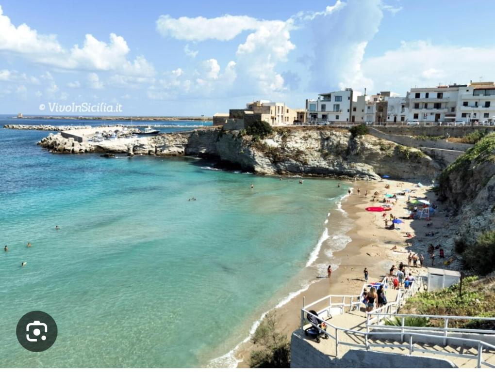 einen Strand mit einer Gruppe von Menschen im Wasser in der Unterkunft Casa vacanze relax in Terrasini