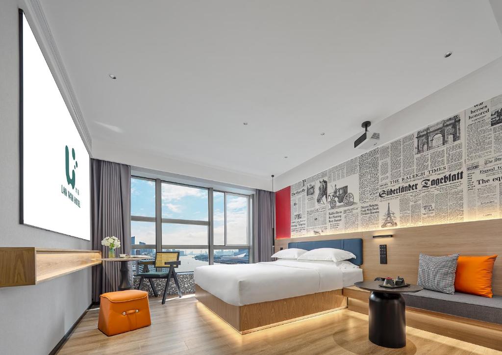 ein Hotelzimmer mit einem Bett und einem Schreibtisch in der Unterkunft Lan Wan Hotel - One Free Cockt ail Per Room--Cha rgeable Airport Pick-up Service in Guangzhou
