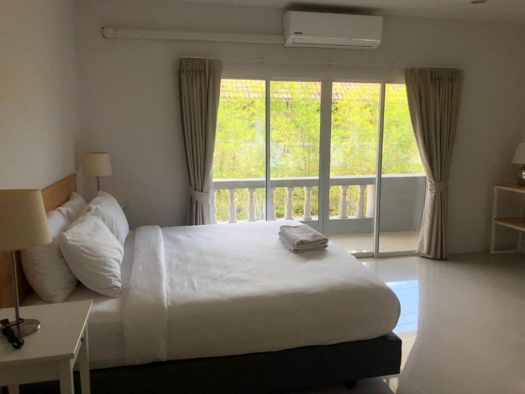ein Schlafzimmer mit einem Bett und einem großen Fenster in der Unterkunft ฺBKK @ Khaolak in Khao Lak