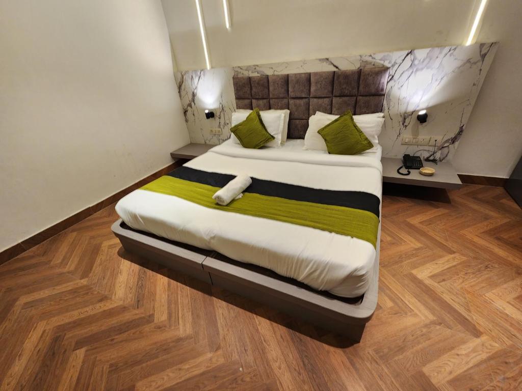 um quarto com uma cama grande e almofadas verdes em Squar Stays em Gurgaon
