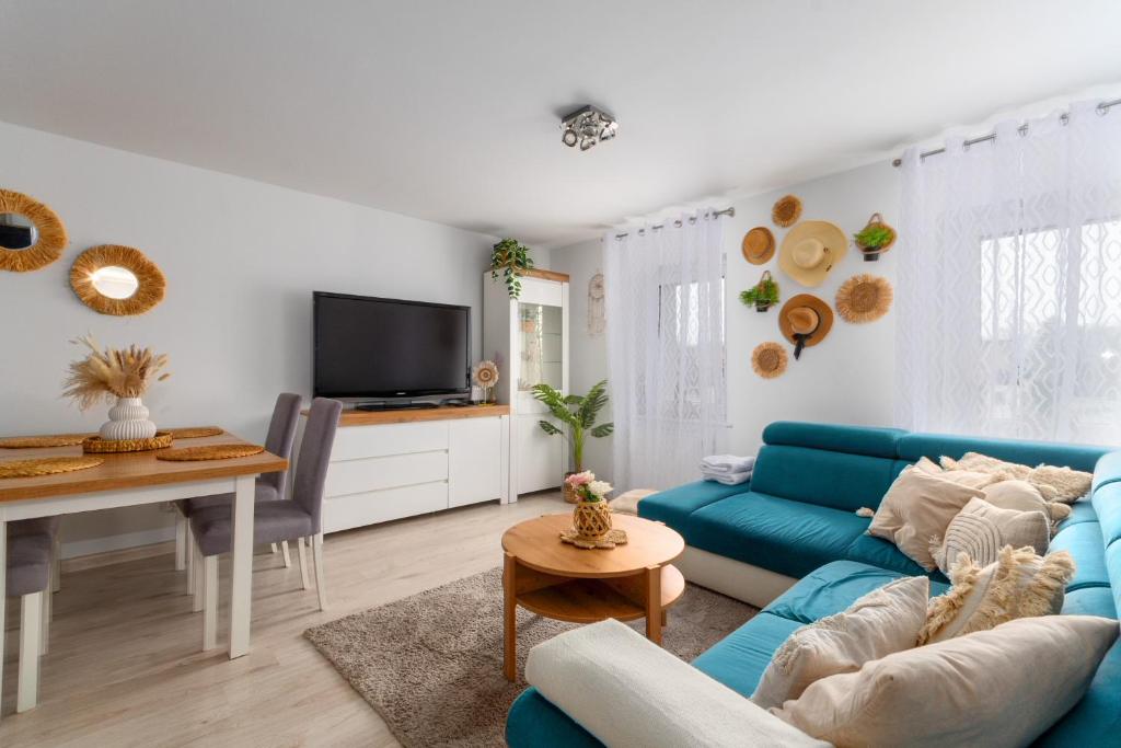 a living room with a blue couch and a table at Pod Trzynastką Cosy Apartment in Jelenia Góra