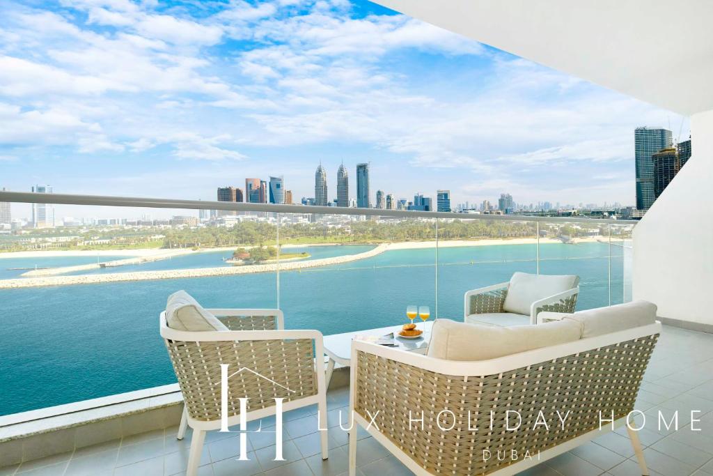 balcón con mesa, sillas y vistas a la ciudad en LUX - Opulent Island Suite 4 en Dubái