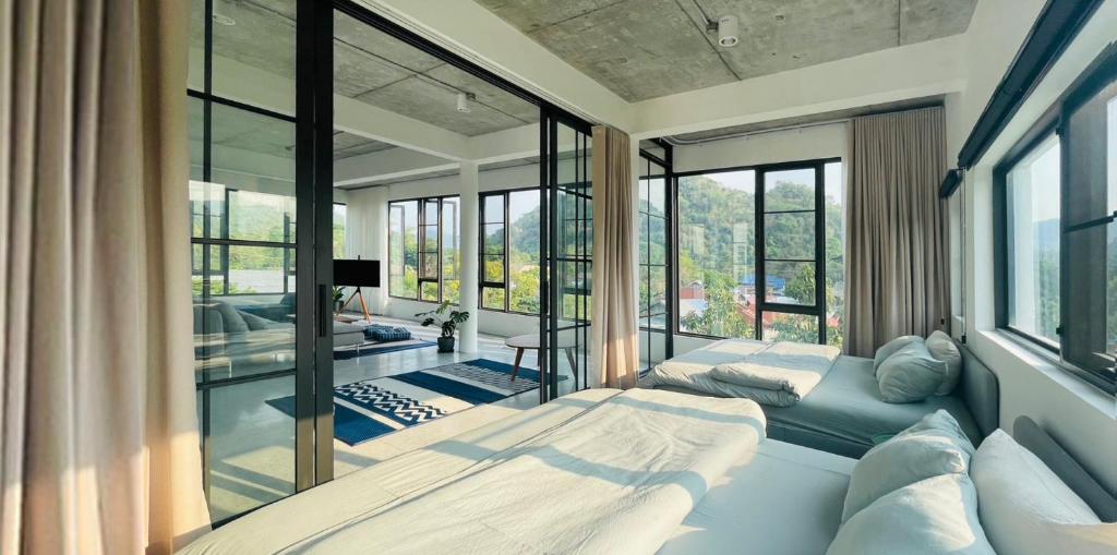 um quarto com 2 camas e uma grande janela em ATATvilla Khaoyai with mountain rooftop view for party and BBQ em Mu Si