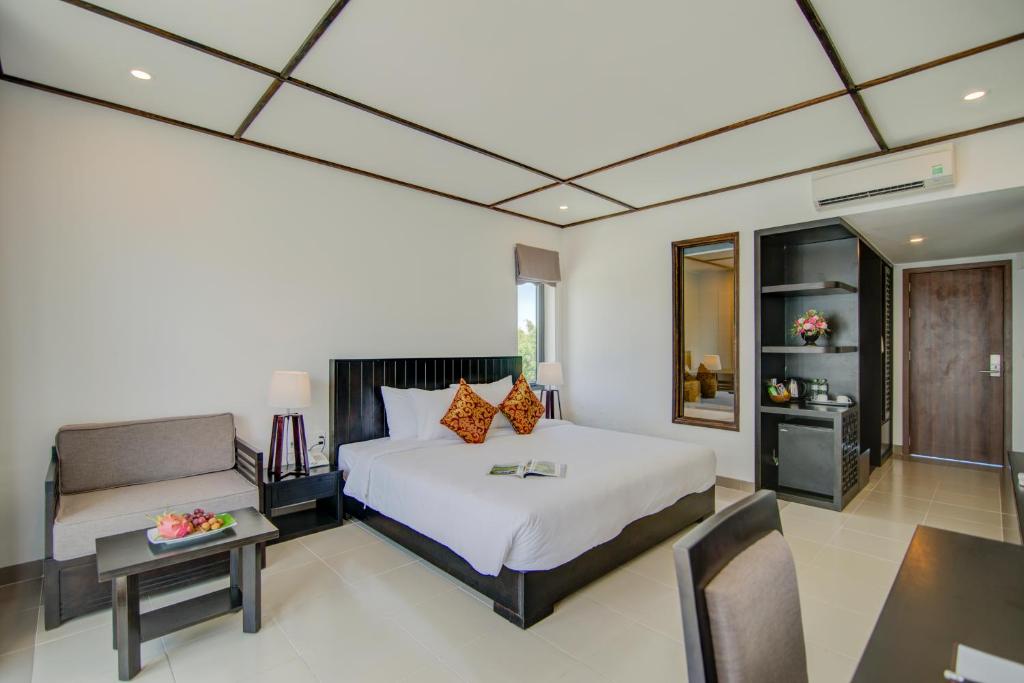 Postel nebo postele na pokoji v ubytování White Lotus Hotel Hoian