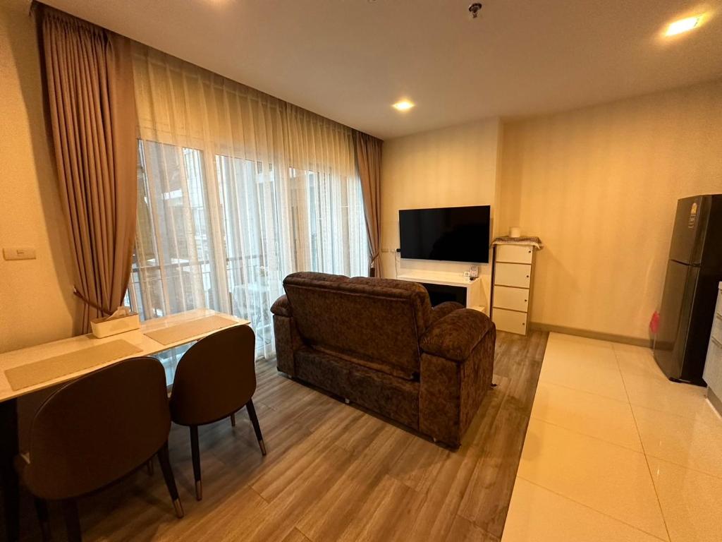 een woonkamer met een bank en een televisie bij The prio apartment chiangmai airport in Chiang Mai