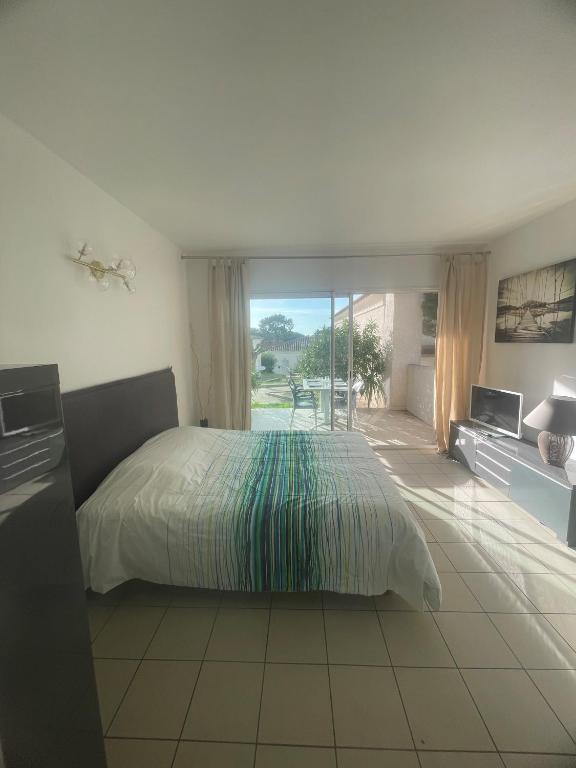 - une chambre avec un lit et une vue sur une terrasse dans l'établissement Studio 28 m2 PORTICCIO Centre, à Porticcio
