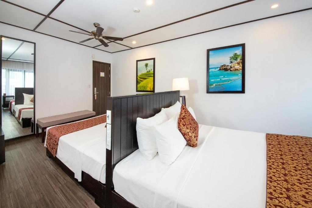 Postel nebo postele na pokoji v ubytování White Lotus Hotel Hoian