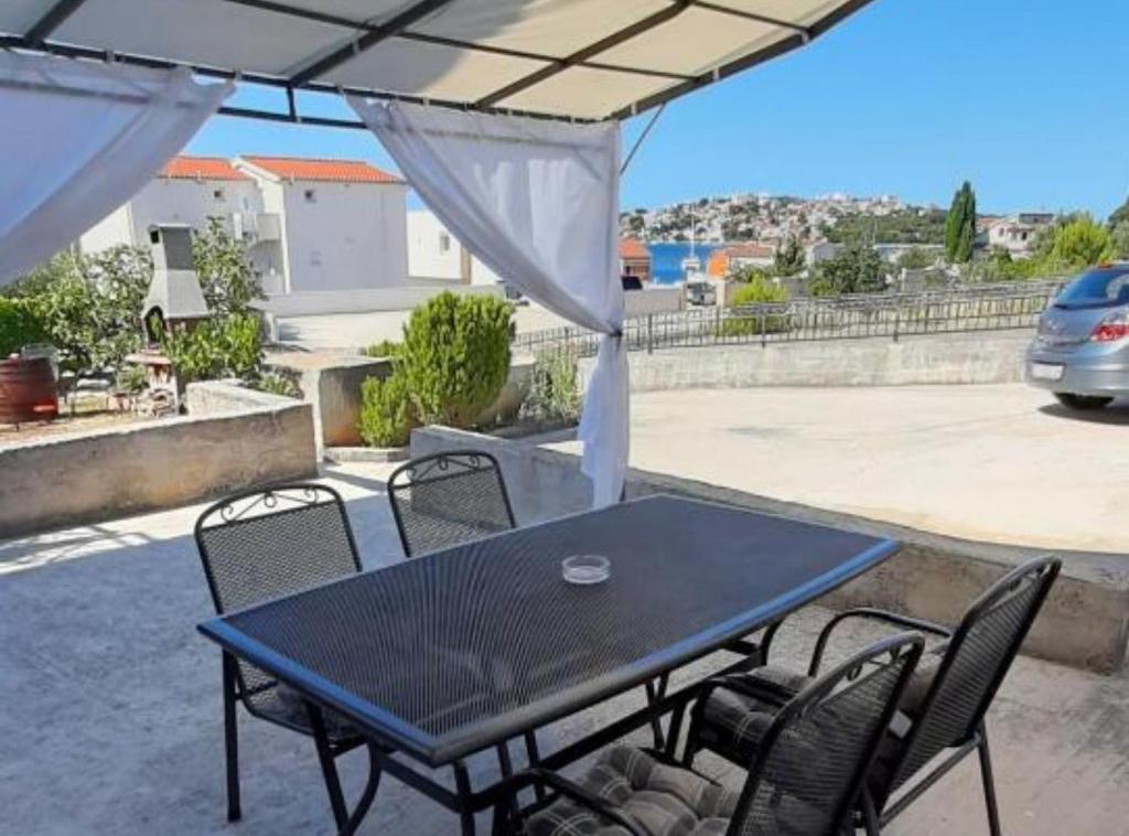 einen Tisch und Stühle unter einem Sonnenschirm auf einer Terrasse in der Unterkunft Apartments J&M 2 in Podglavica