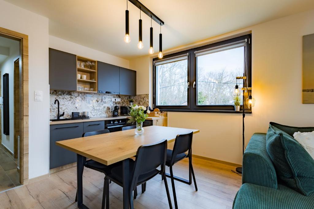 cocina y comedor con mesa y sofá en Szemespart Residence Apartmanok By BLTN, en Balatonszemes