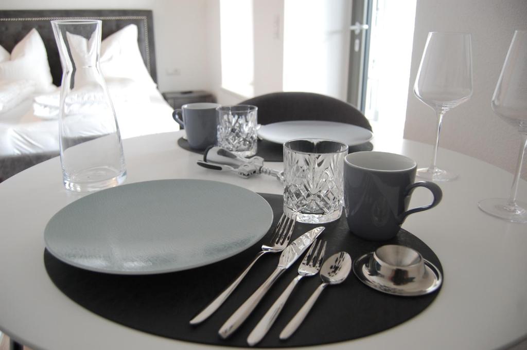 een tafel met een bord en zilveren bestek erop bij myQuartier - Central City DeLuxe Apartments in Innsbruck