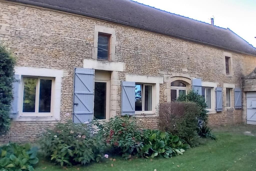 une ancienne maison en briques avec portes et fenêtres bleues dans l'établissement Une pause près de Pégasus Bridge, à Ranville