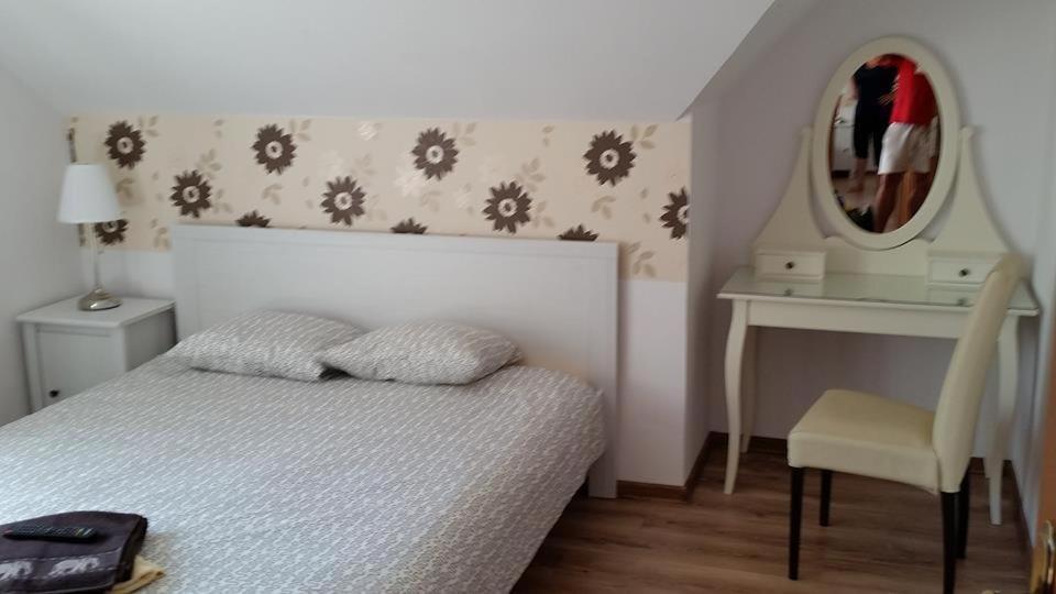 a bedroom with a bed and a mirror and a chair at Pension Klarissa in Sovata