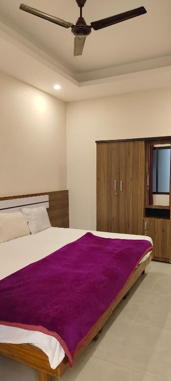 a bedroom with a purple blanket on a bed at Remarita Holidays in Panamaram
