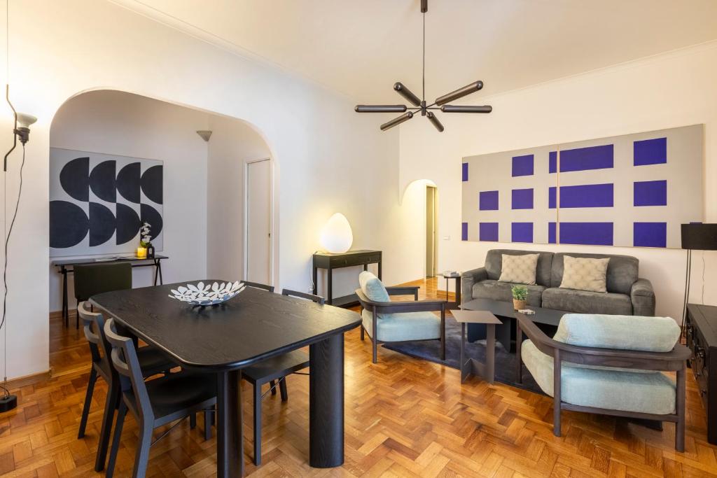 ein Wohnzimmer mit einem Tisch und einem Sofa in der Unterkunft ROMAC - Condotti Suite by Spanish Steps in Rom