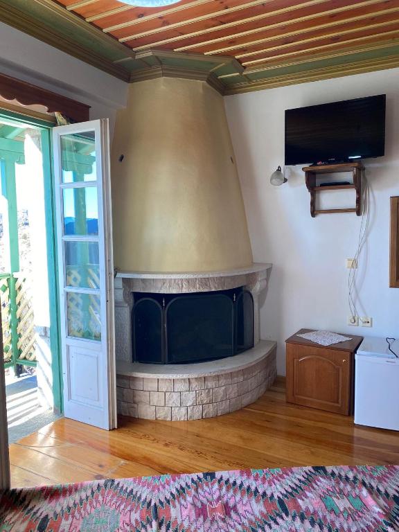 a living room with a fireplace with a flat screen tv at Hotel Zagori in Skamnéllion