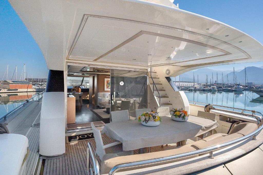 a balcony on a yacht with a table and chairs at Yacht Joy 4 cabin in Porto Cervo