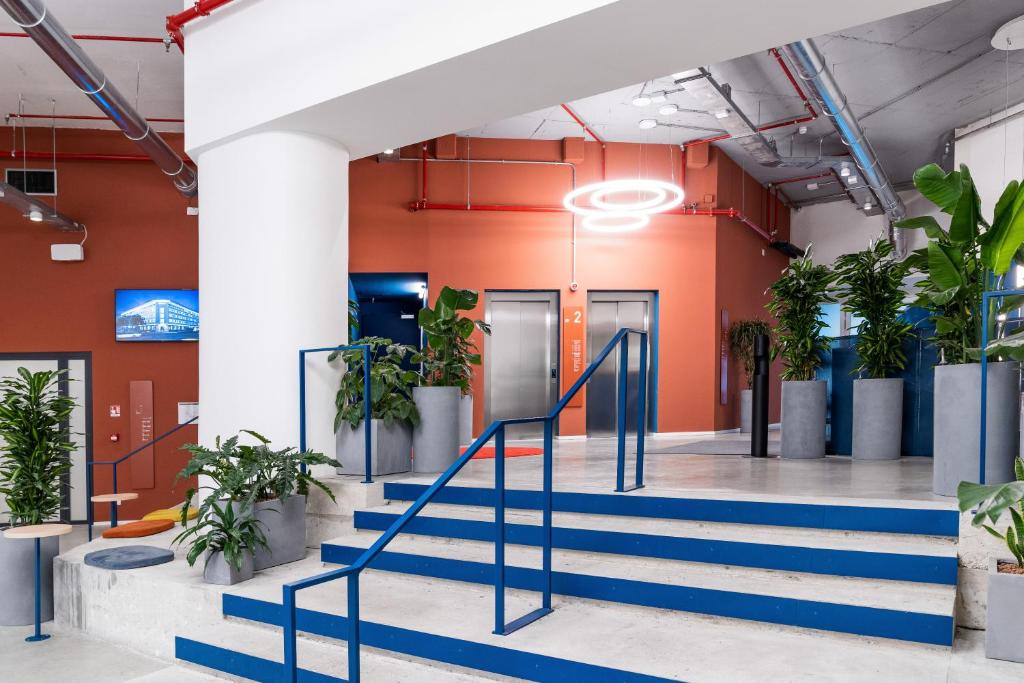 a hallway with stairs and potted plants at aparto Milan Ripamonti in Milan