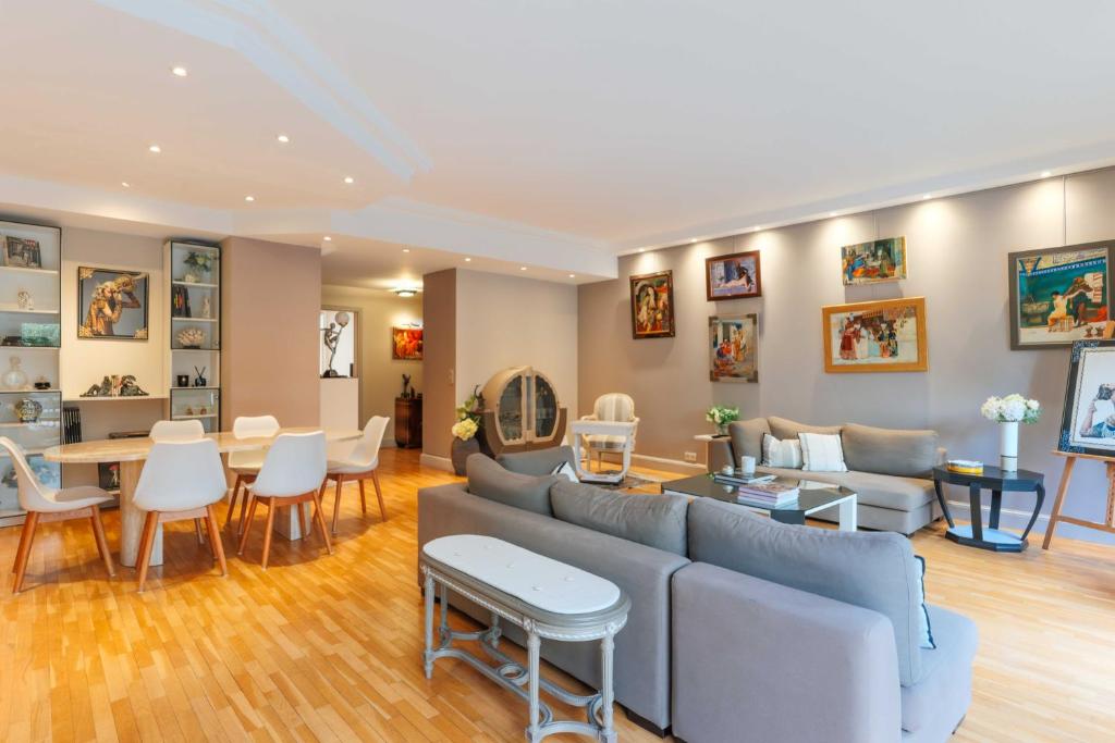 a living room with a couch and a table and chairs at Air-conditioned apartment with terrace Hauts de Seine in Neuilly-sur-Seine