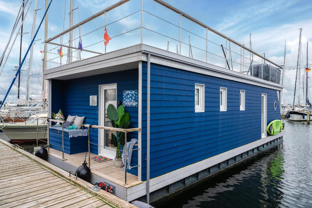 una casa azul en un barco en el agua en Blåbær en Egernsund