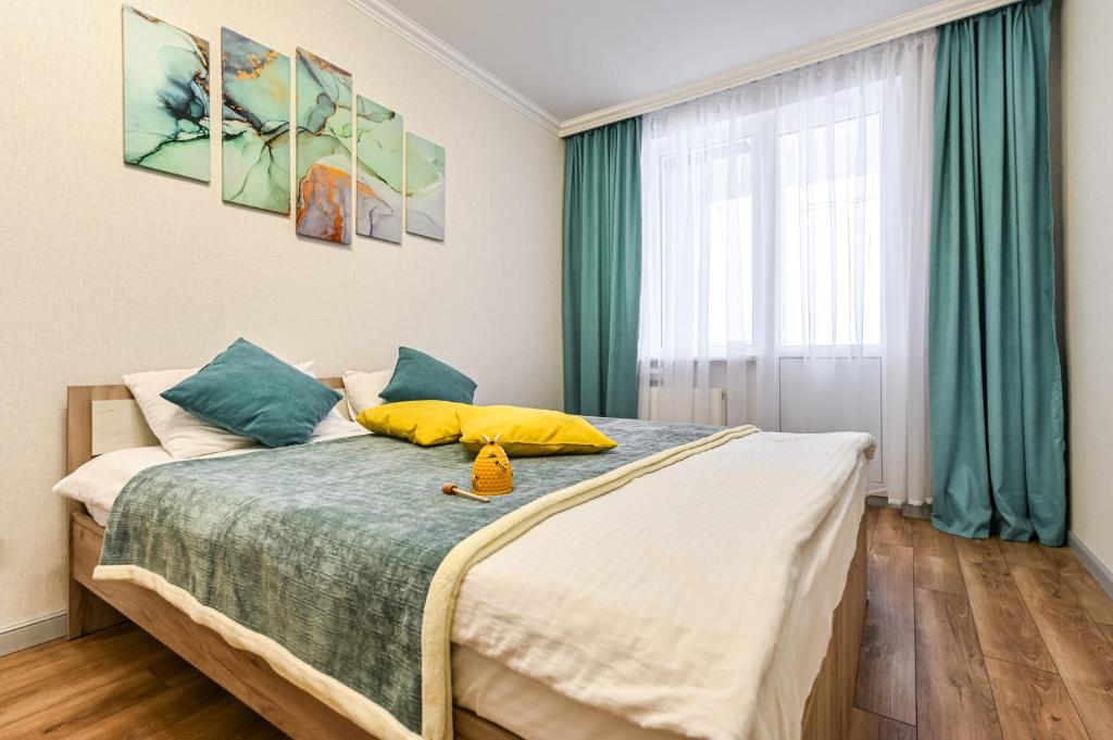 um quarto com uma cama com almofadas amarelas e azuis em Однокомнатная для 4 гостей недалеко от аэропорта em Astana