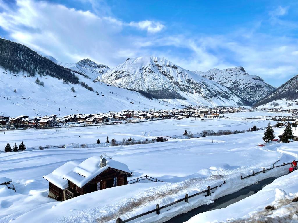 uma cidade coberta de neve com montanhas ao fundo em Appartamenti - Formula Roulette em Livigno