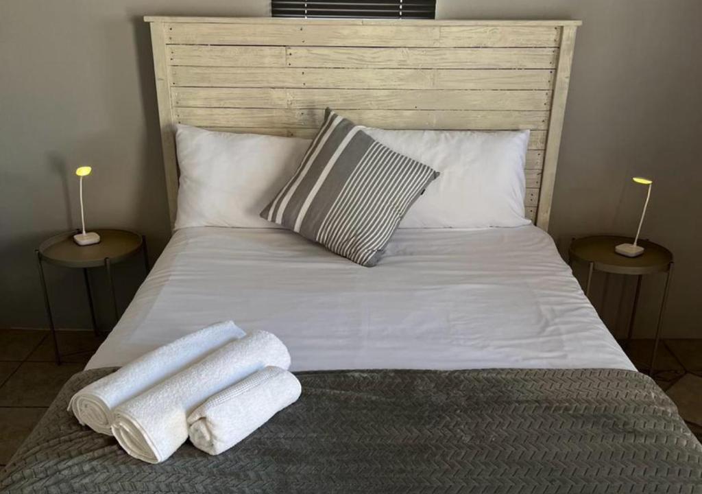 a bed with two towels on it with two lamps at Stay-A-While by Ustay in Saldanha
