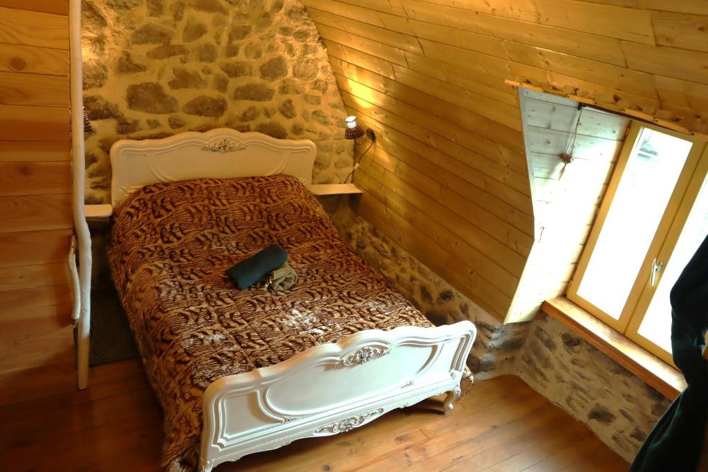 ein Schlafzimmer mit einem Bett in einem Blockhaus in der Unterkunft La Verte Salamandre in Allanche