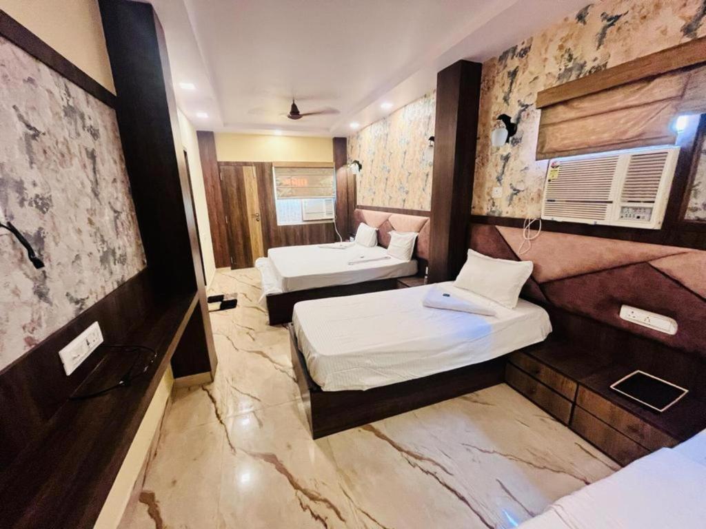 a hotel room with two beds in a room at KS PAYING GUEST HOUSE in Varanasi