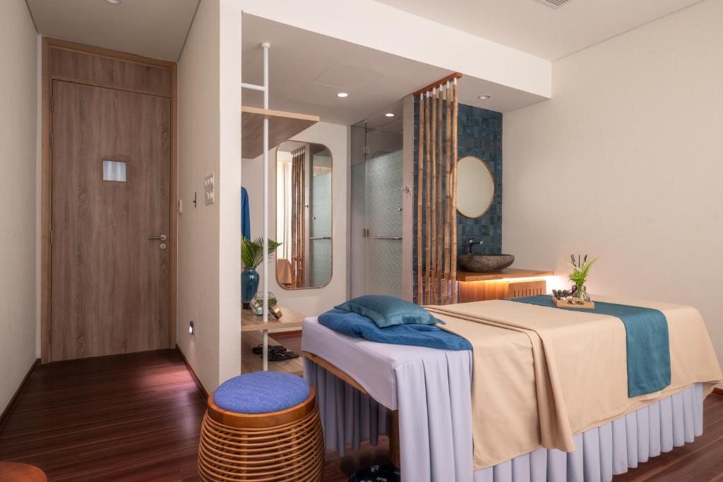 a bedroom with a large bed and a mirror at TTC Van Phong Bay Resort - Himalaya Sauna & Steam Retreat Included in Ninh Hòa