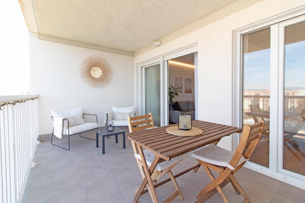comedor con mesa y sillas en el balcón en Global Properties, Moderno apartamento con piscina y terraza en la playa de Canet, en Canet de Berenguer