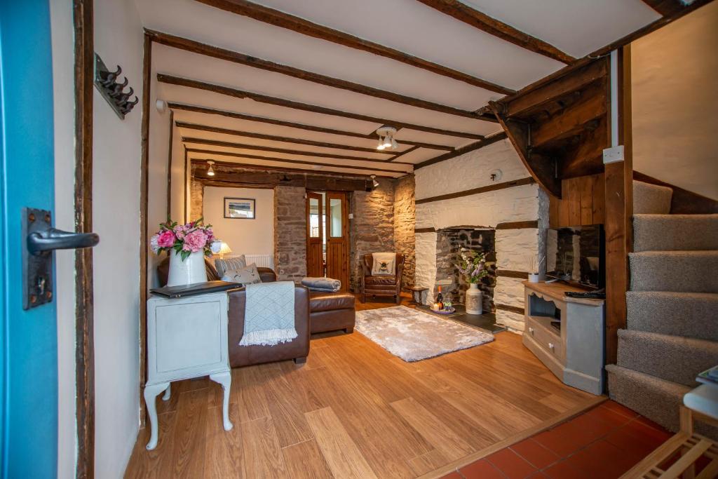 sala de estar con sofá y chimenea en Central Brecon, Pretty Victorian Cottage, en Brecon