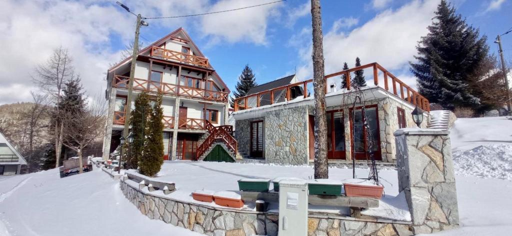 科帕奧尼克的住宿－Apartmani Vujanac，前方雪中的房子