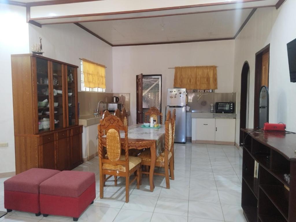 a kitchen with a table and chairs and a refrigerator at Banaga Residence in Talibon