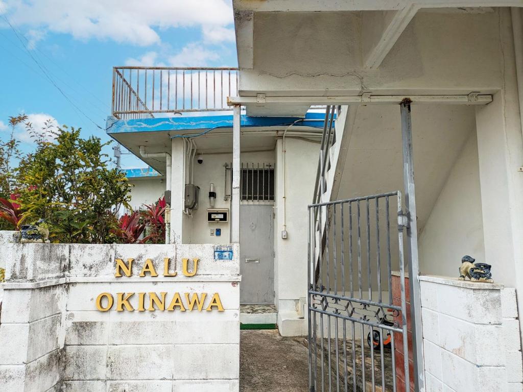 um edifício branco com um portão e uma varanda em nalu okinawa - Vacation STAY 00877v em Uruma