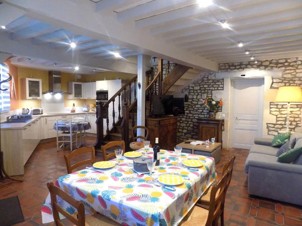 a kitchen and a dining room with a table and chairs at Meschers sur Gironde - MAISON mitoyenne EN PIERRES - proximité commerces in Meschers-sur-Gironde