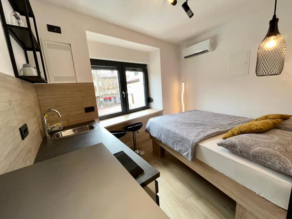 - une petite chambre avec un lit et un lavabo dans l'établissement Apartmani Audacia Crikvenica, à Crikvenica