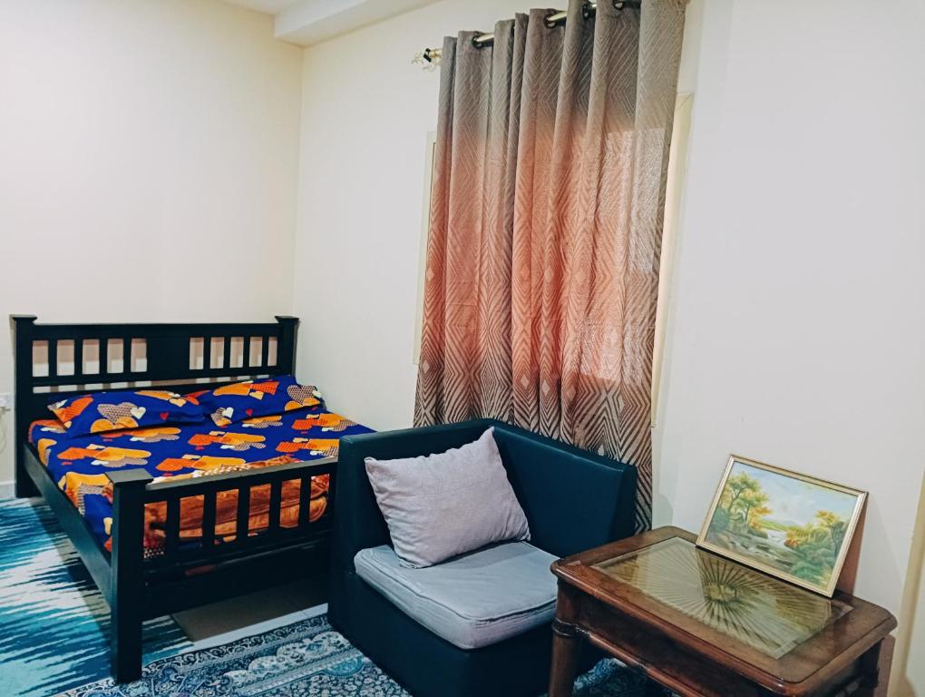 a bedroom with a bed and a chair and a table at Place where stay for good time in Ajman 