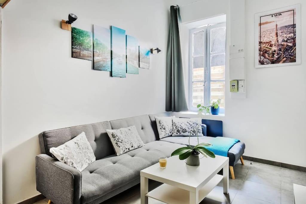 a living room with a couch and a table at Le cocon de Saint-Clair in Caluire-et-Cuire