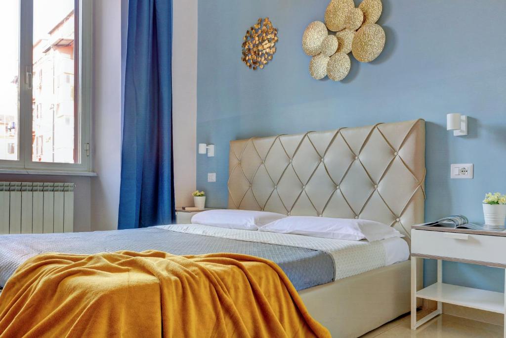 sypialnia z łóżkiem z żółtym kocem w obiekcie Claudia House Roma Termini w Rzymie