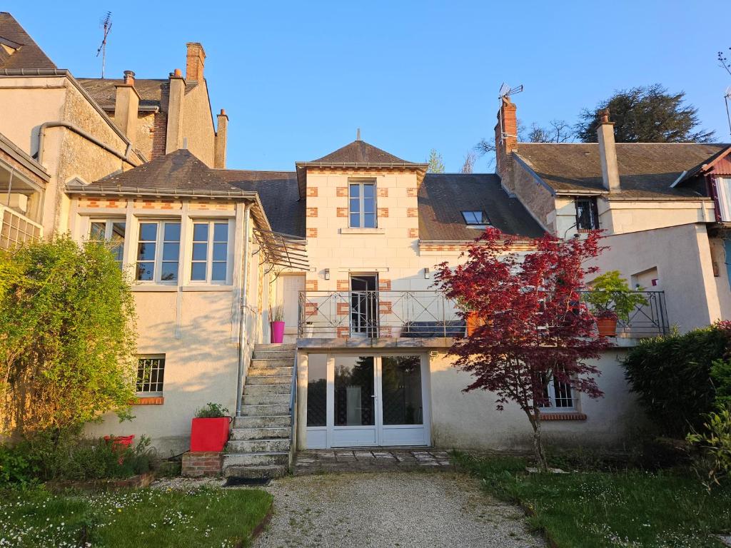 uma casa grande com uma porta branca num quintal em Entre Château et Loire. em Chaumont-sur-Loire