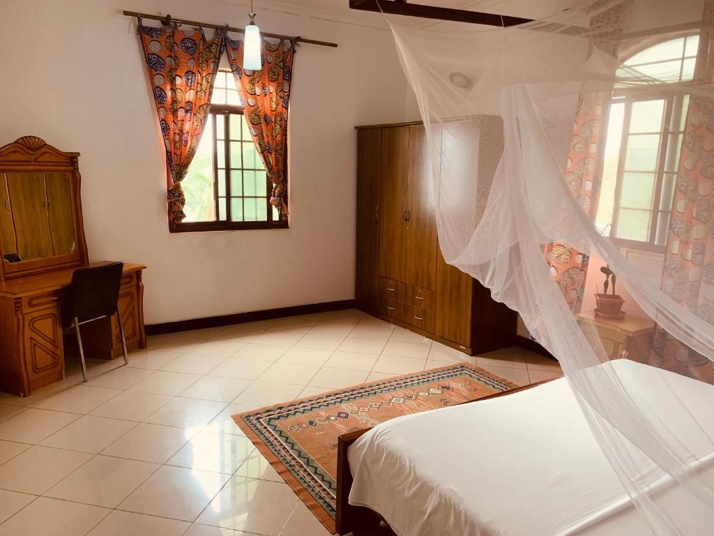 een slaapkamer met een bed met een klamboe bij Good Vibes Stay in Dar es Salaam