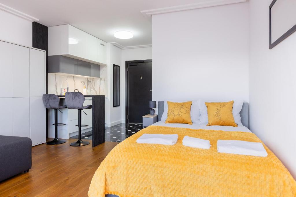 ein Schlafzimmer mit einem großen Bett und einer gelben Decke in der Unterkunft Marvipol Studio with the View in Danzig